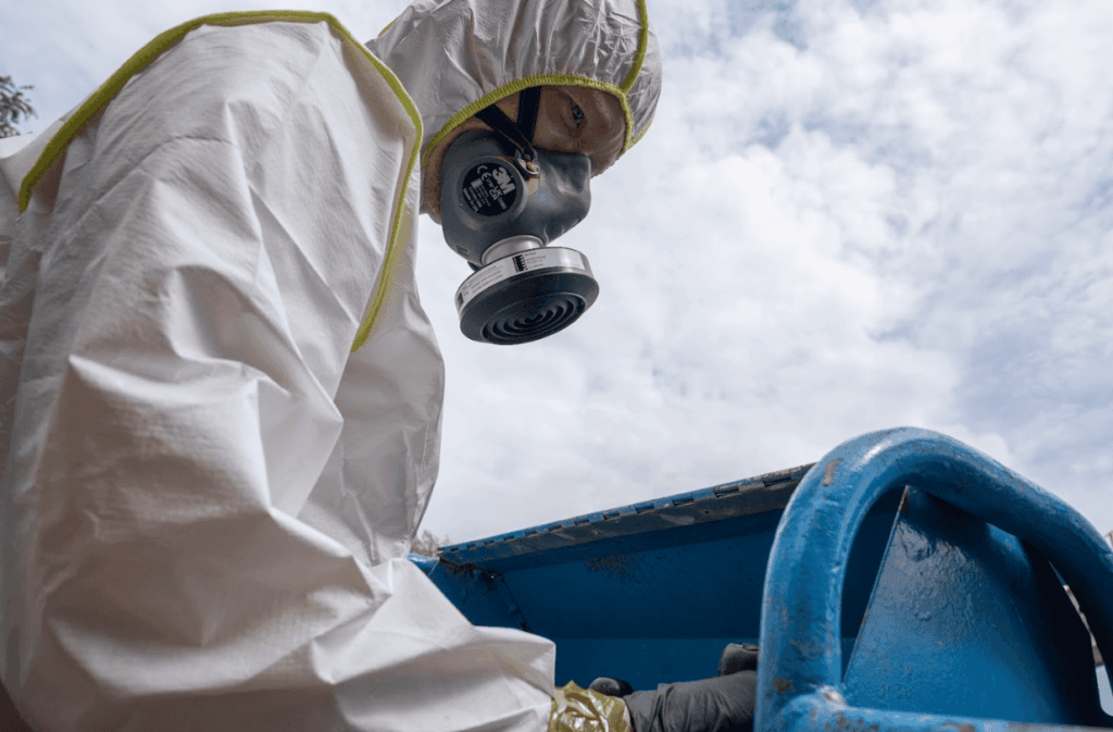 Diagnostiqueur BTP Diagnostics équipé d’une combinaison de protection lors d’un repérage PEMD sur site.