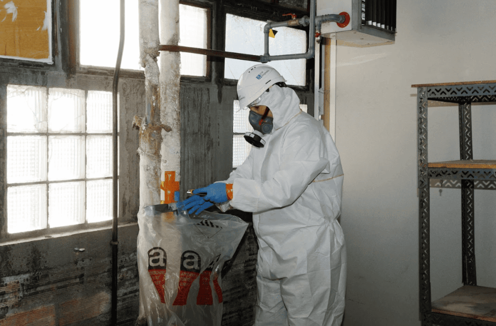 Diagnostiqueur BTP Diagnostics équipé d’une combinaison de protection lors d’un repérage PEMD sur site.