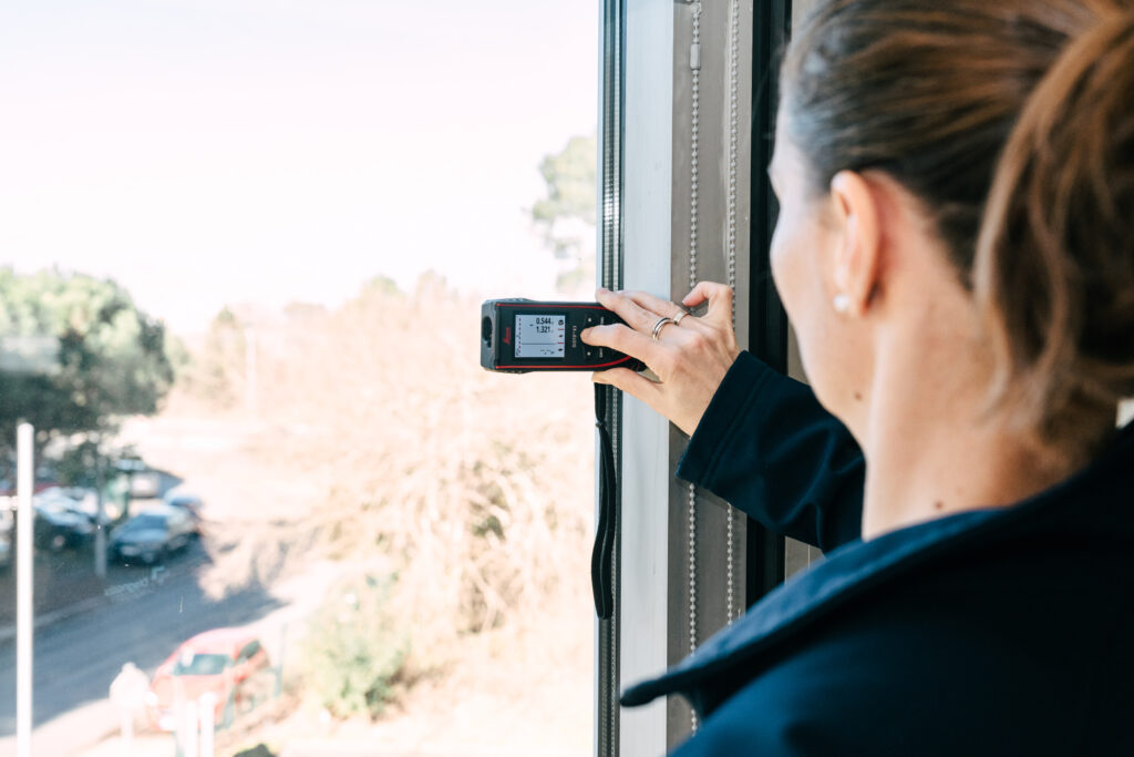 Technicien réalisant un contrôle thermique en façade lors d’un diagnostic immobilier.
