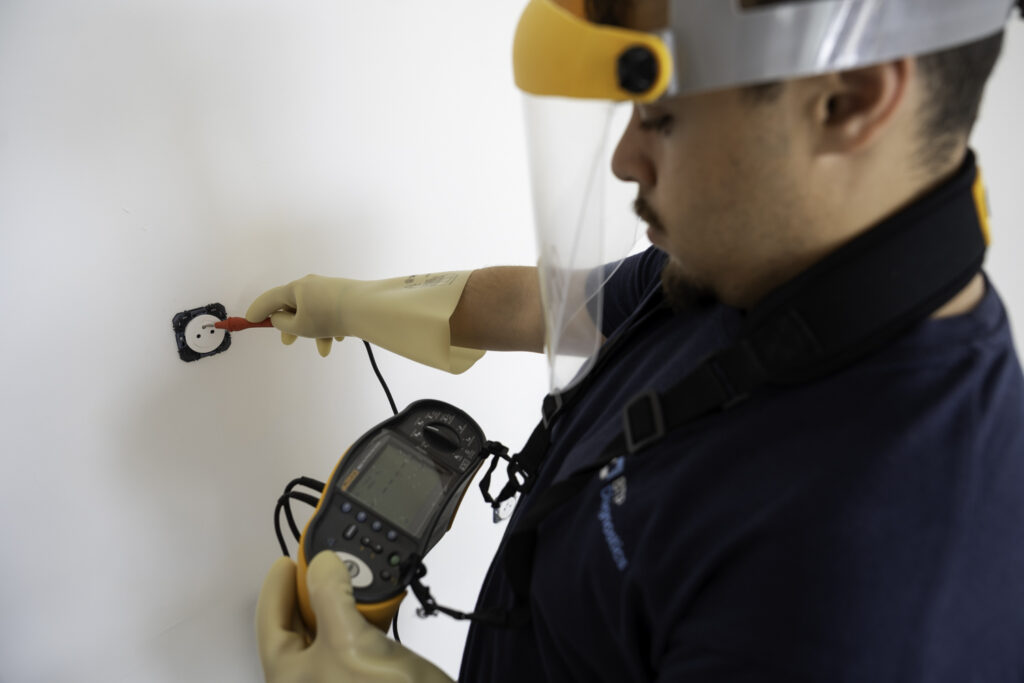 Technicien réalisant un diagnostic électrique dans un logement