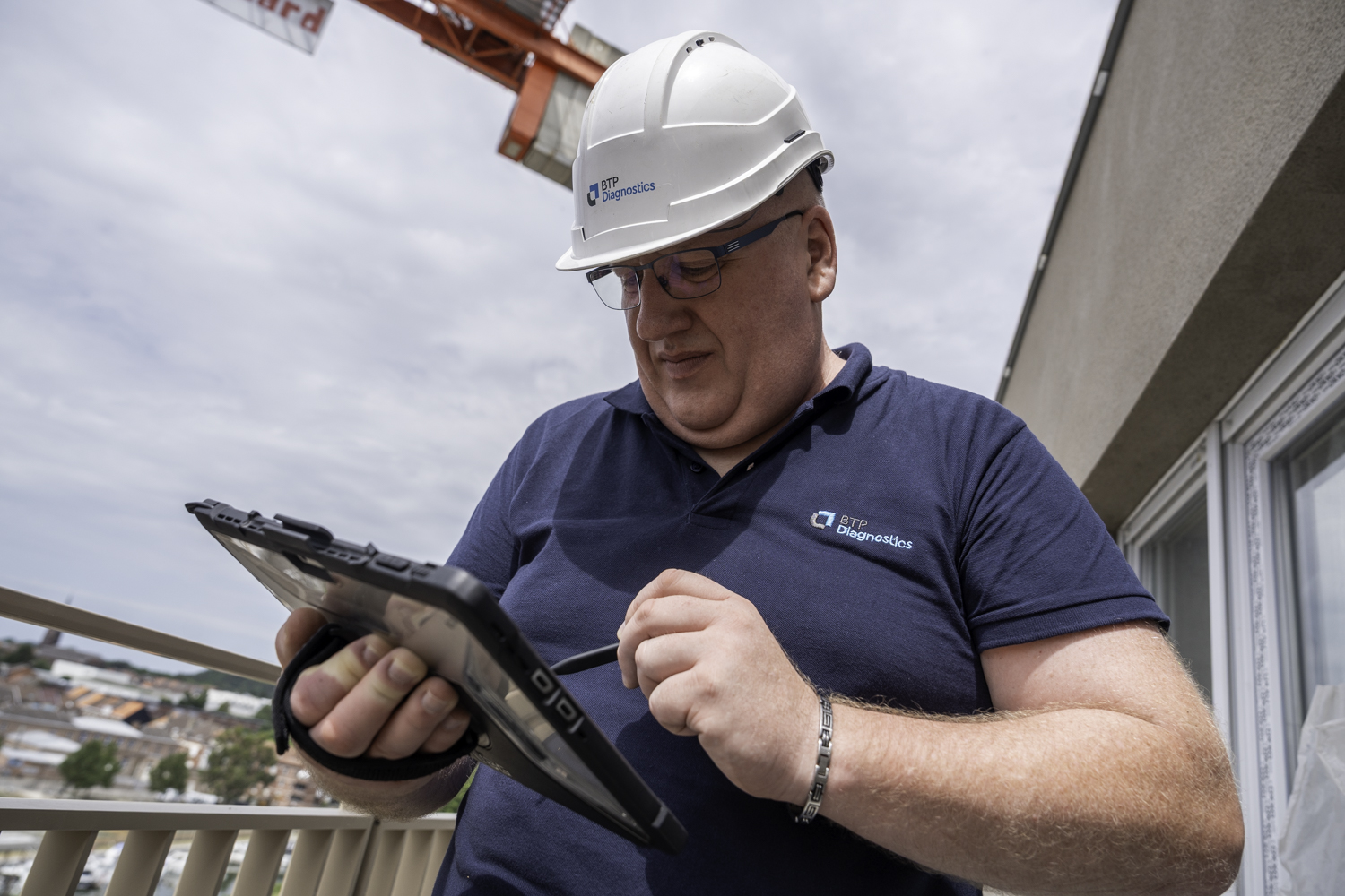 Technicien BTP Diagnostics réalisant un relevé sur tablette lors de l’inspection d’un immeuble dans le cadre du DTG.